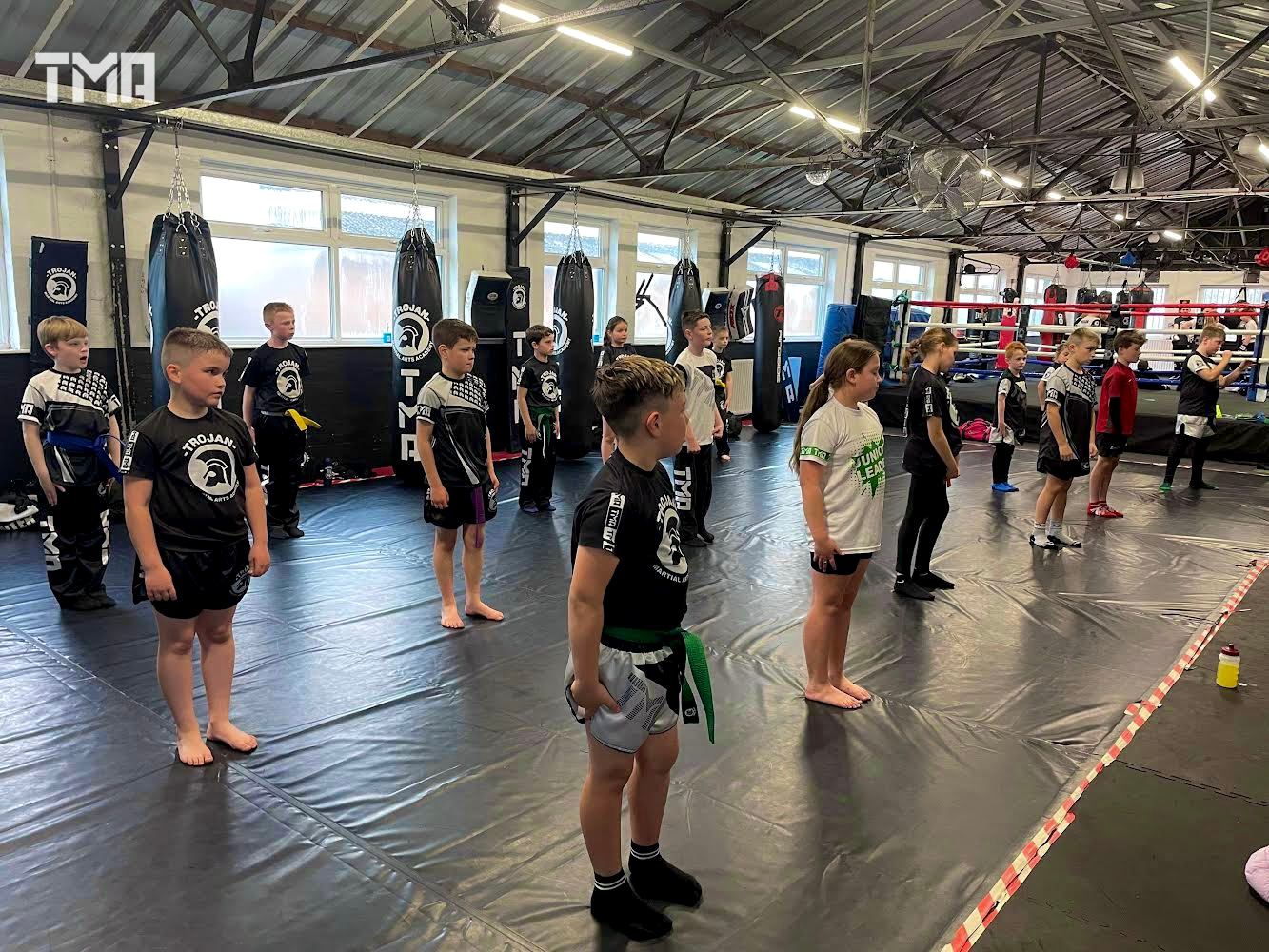 A junior class lined up on the mats at Trojan Martial Arts Academy